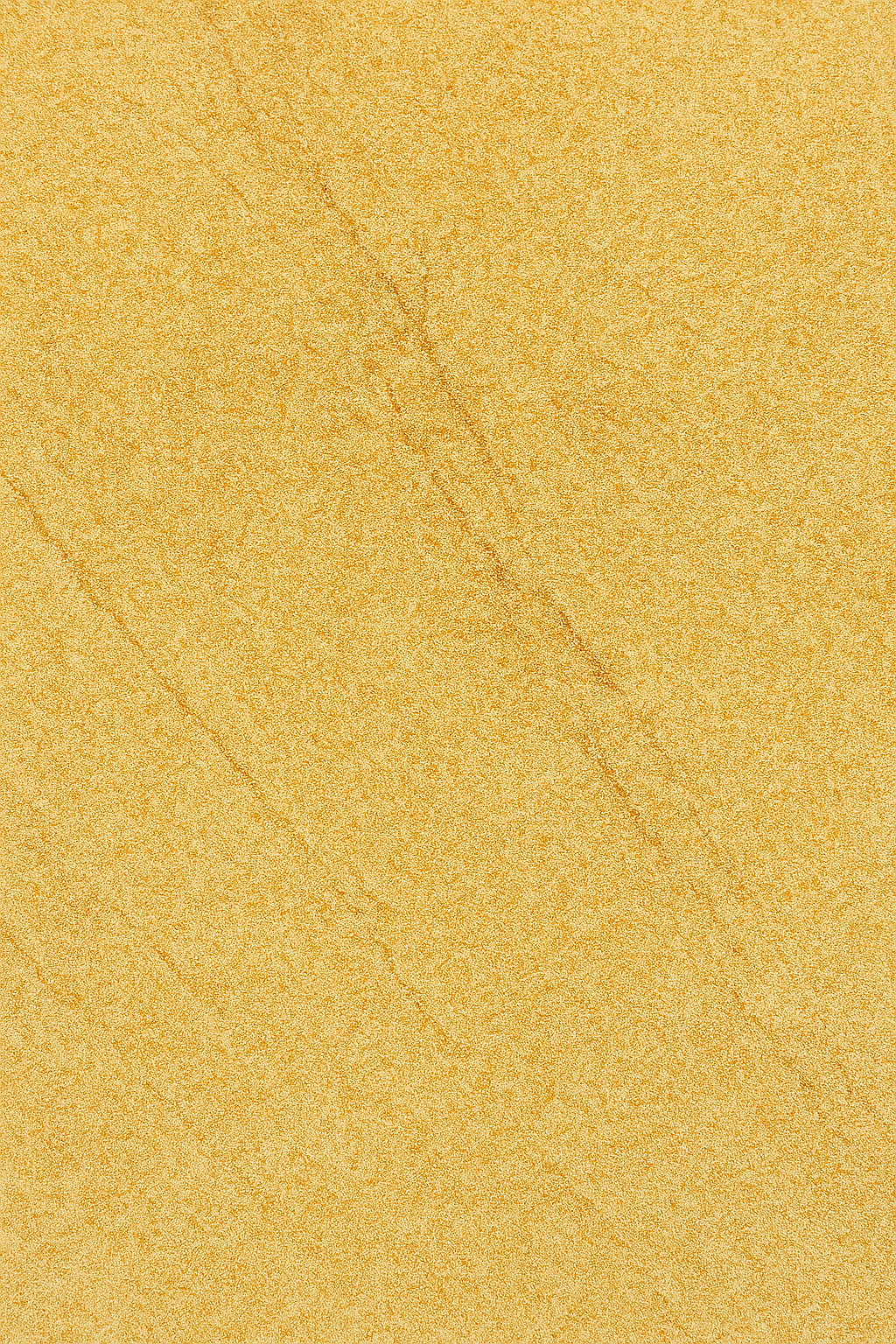 Close-up view of natural Jaisalmer stone with golden-yellow color and textured surface.